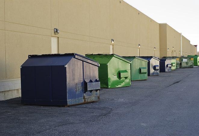 a construction worker moves construction materials near a dumpster in Blue Grass IA